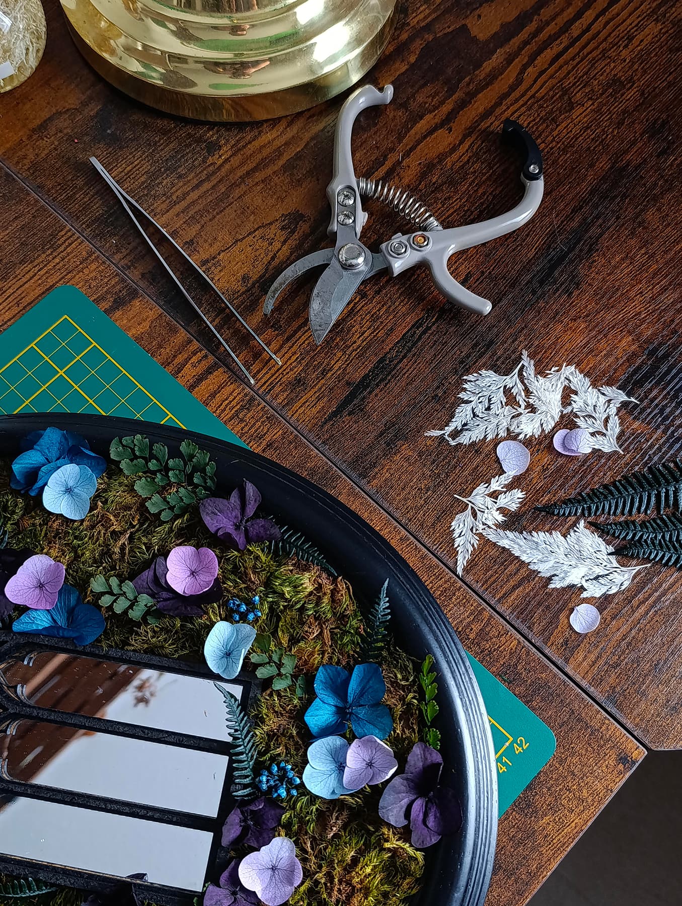 Commande personnalisée labo bouture avec des pinces, des fleurs, dans un style overgrown, cottage sur une table en bois foncé