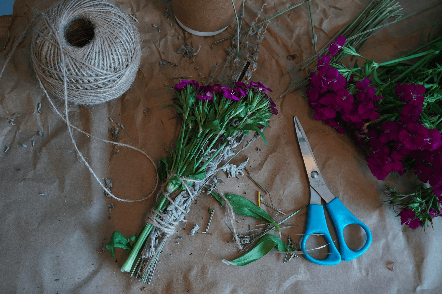 Atelier créatif labo bouture avec des fleurs , de la corde et un ciseau sur une table