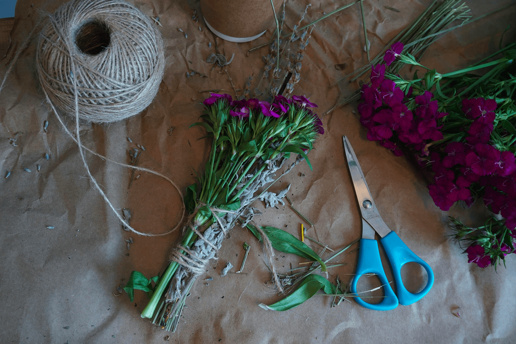 Atelier créatif labo bouture avec des fleurs , de la corde et un ciseau sur une table