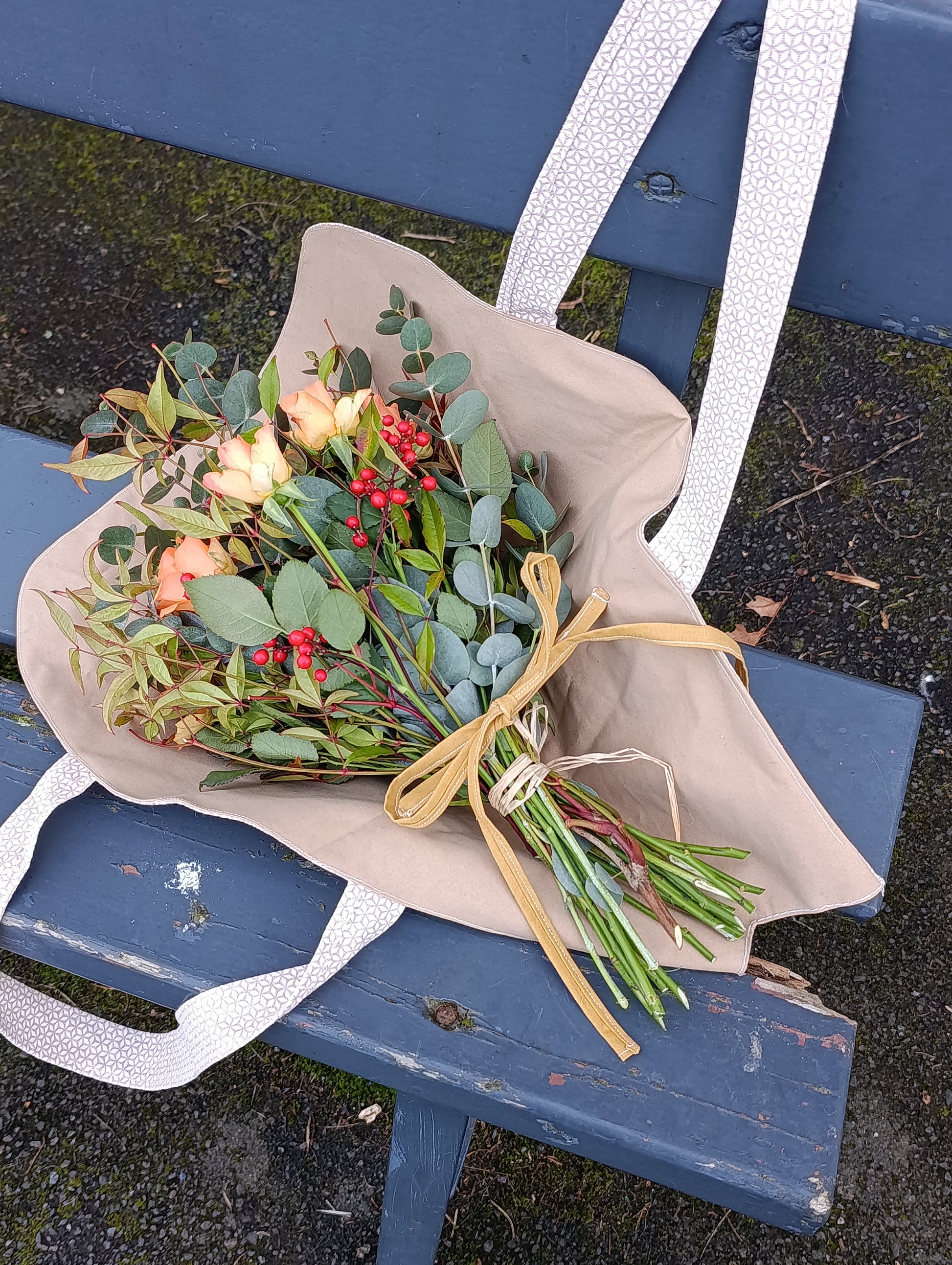 bouquet de fleurs dans sac sur banc