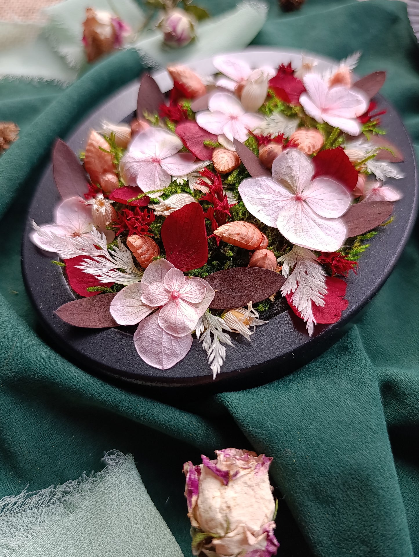Détails cadre végétal fleurs séchées sur tissu vert
